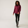 Woman wearing a maroon pullover, black leggings, and hiking boots on a white background
