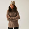 Woman wearing a brown fleece pullover and beanie against a plain background