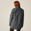 Person wearing a gray jacket on a plain background