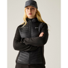 A woman wearing a lightweight zip-up puffer vest with a blackquilted front and black sleeves, standing against a solid light beige background.