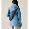 a woman wearing a blue jacket on beige background with black bag and brown shorts