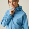 a woman in a blue full zip jacket holding the zipper