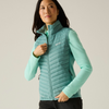 a women tying the zipper of a ivy moss gilet with a green fleece underneath and black shorts