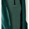 Close-up of a dark teal outdoor jacket with a vertical zippered pocket and a fleece-lined interior, showing a small black logo on the chest and care icons printed on the inner lining.