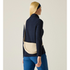 A woman shown from the back wearing a navy long-sleeve mock neck top, blue leggings, a navy headband, and carrying a beige crescent-shaped crossbody bag against a plain light beige studio background.