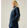 a woman standing wearing a navy rainjacket with a cream bag strap over her shoulder