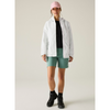 a woman wearing a white rainjacket, black top underneath, green shorts, pink hat, black shoes with off white background