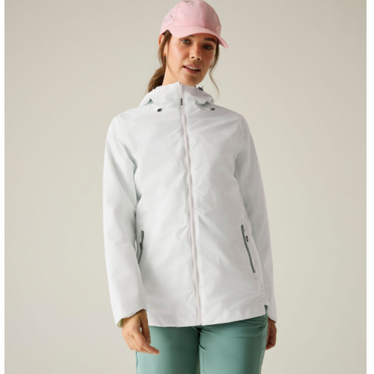 A woman wearing a white fleece zip-up jacket and a pink cap, paired with green leggings, against a solid light beige background.